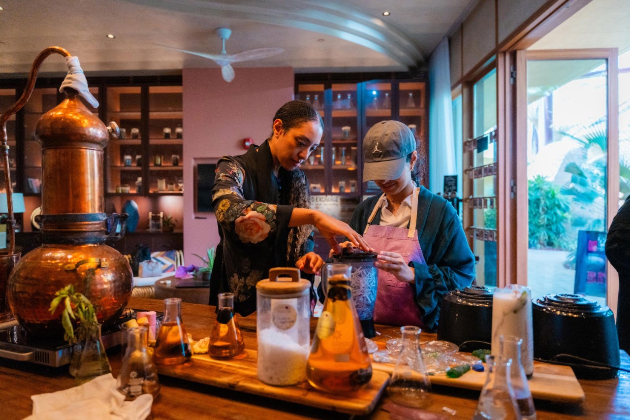 At Earth Lab, Raneem shreds paper with guidance from Dalal, Training Manager at the resort, as part of a recycling activity where guests turn shredded paper into a bespoke painting