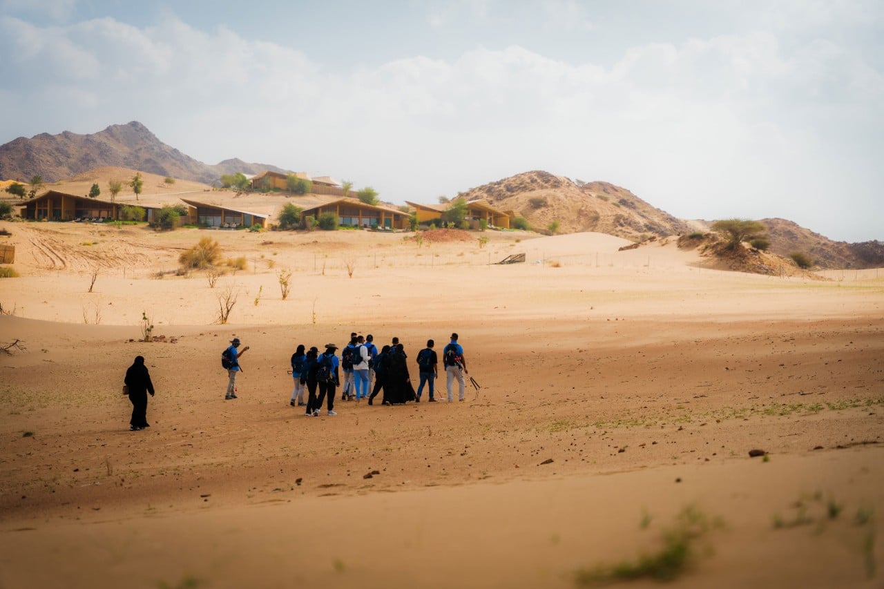 Guests hiking through the dunes near Six Senses Southern Dunes, guided by the Akun team