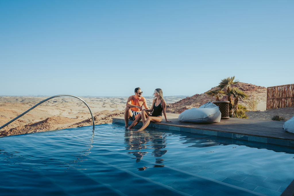 A couple enjoying their time swimming in Red Sea resorts, surrounded by stunning natural scenery.
